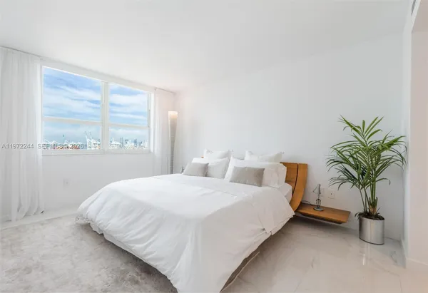a bedroom with a bed and a large window