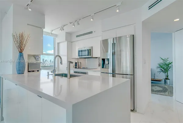 a kitchen with granite countertop a refrigerator and a sink