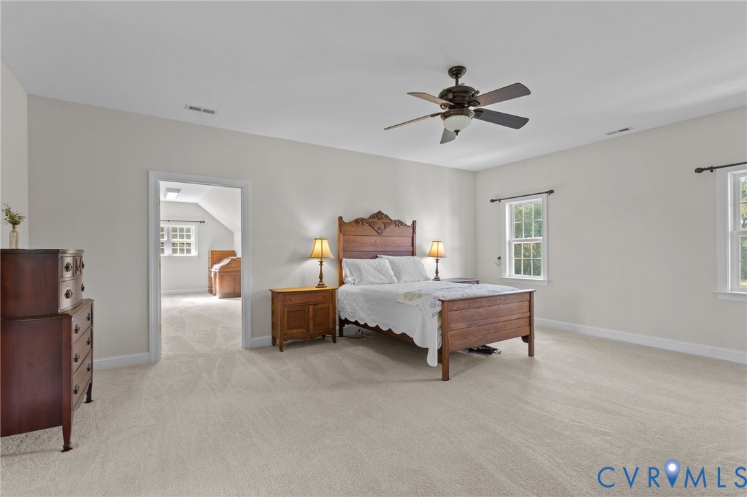 16431 River Road Chesterfield, VA 23838 - Photo 20 of 28 a spacious bedroom with a bed and a chandelier