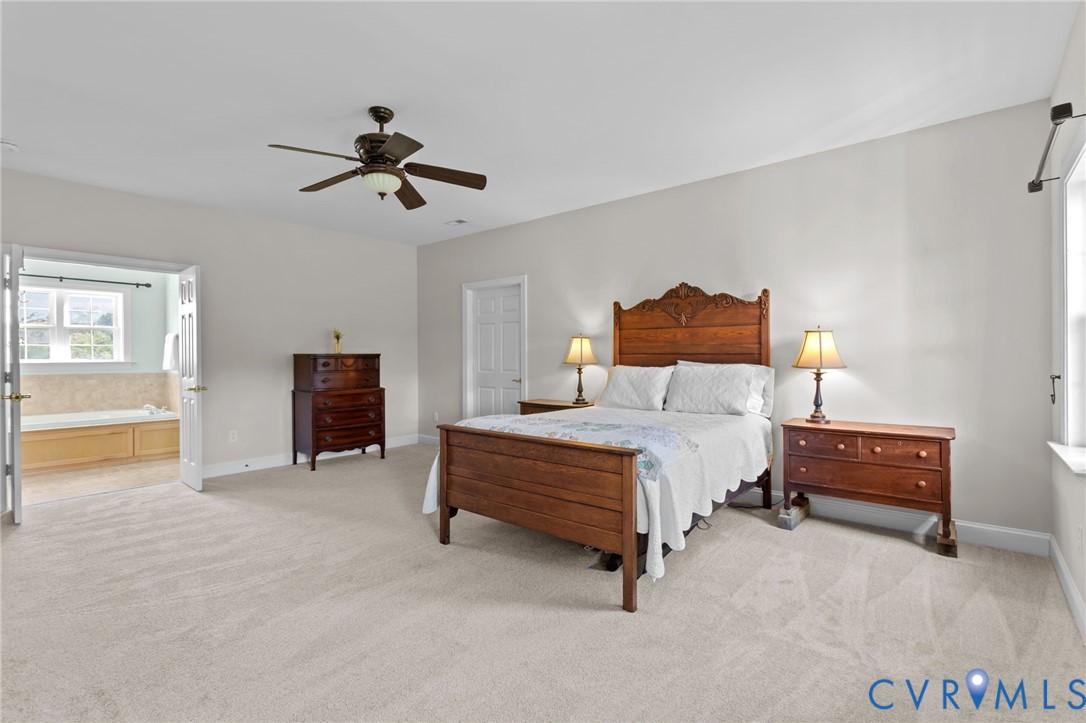 16431 River Road Chesterfield, VA 23838 - Photo 21 of 28 a spacious bedroom with a bed and a chandelier