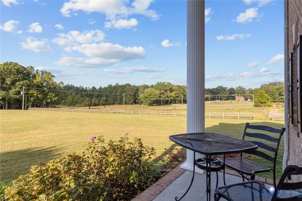 a view of a lake from a balcony with furniture