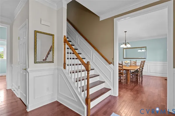 a view of a hallway with wooden floor stairs