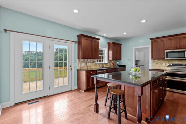 a kitchen with a stove a refrigerator and a dining table with wooden floor