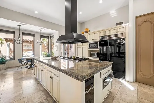 a kitchen with stainless steel appliances kitchen island granite countertop a stove and a sink