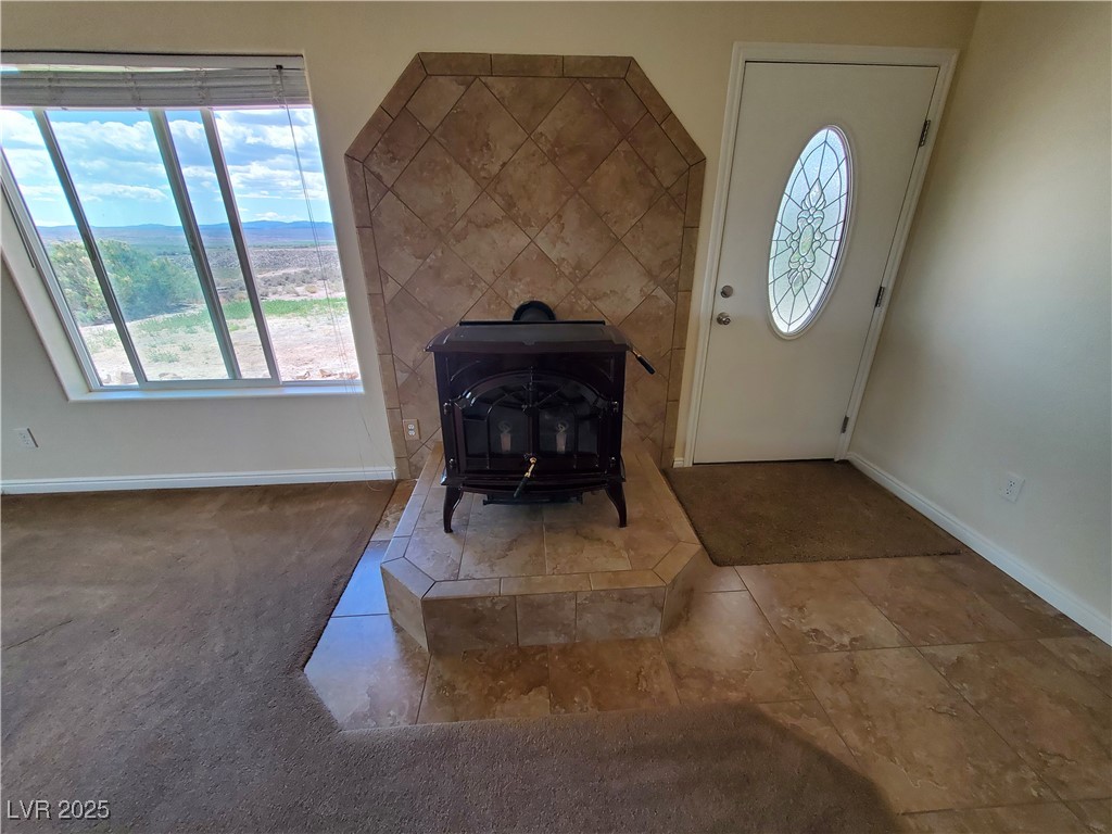 5272 Truman Lane Caliente, NV 89008 - Photo 17 of 39 Tiled foyer with a wood stove, baseboards, and healthy amount of natural light
