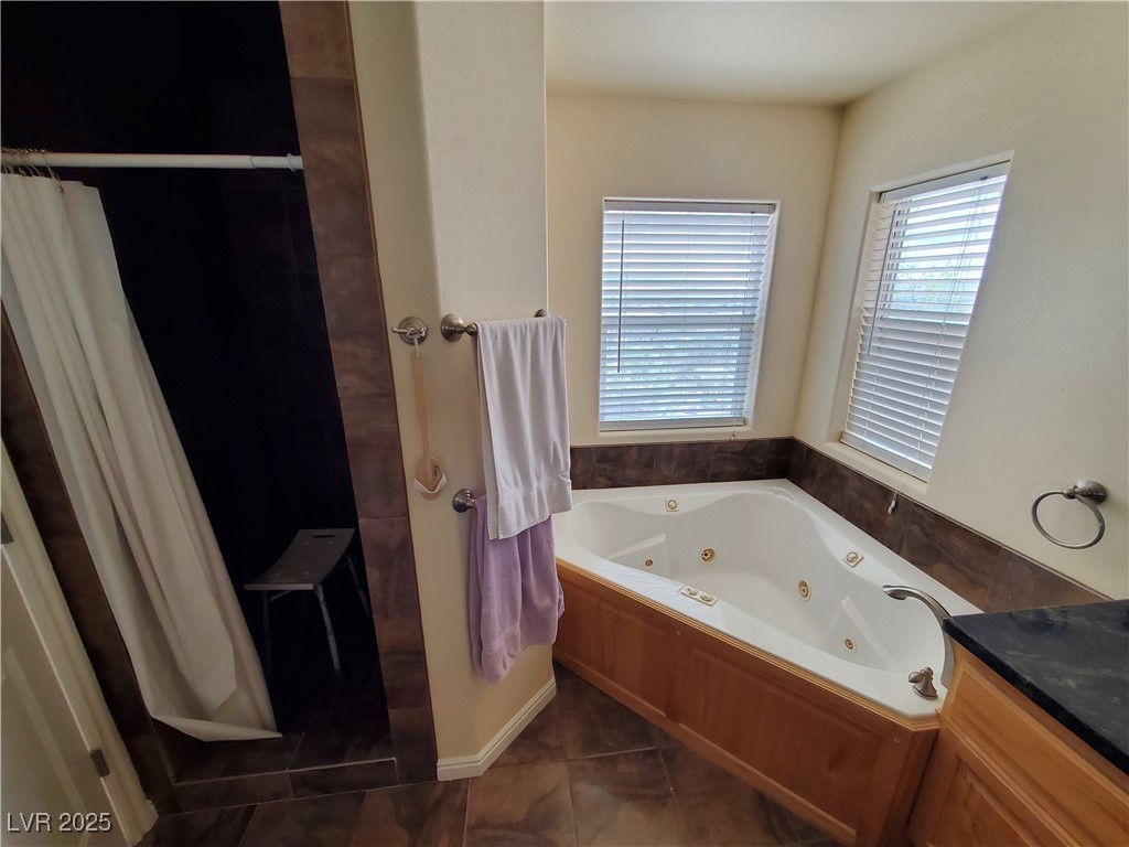 5272 Truman Lane Caliente, NV 89008 - Photo 2 of 39 Bathroom with a jetted tub, tile patterned floors, a shower, and vanity