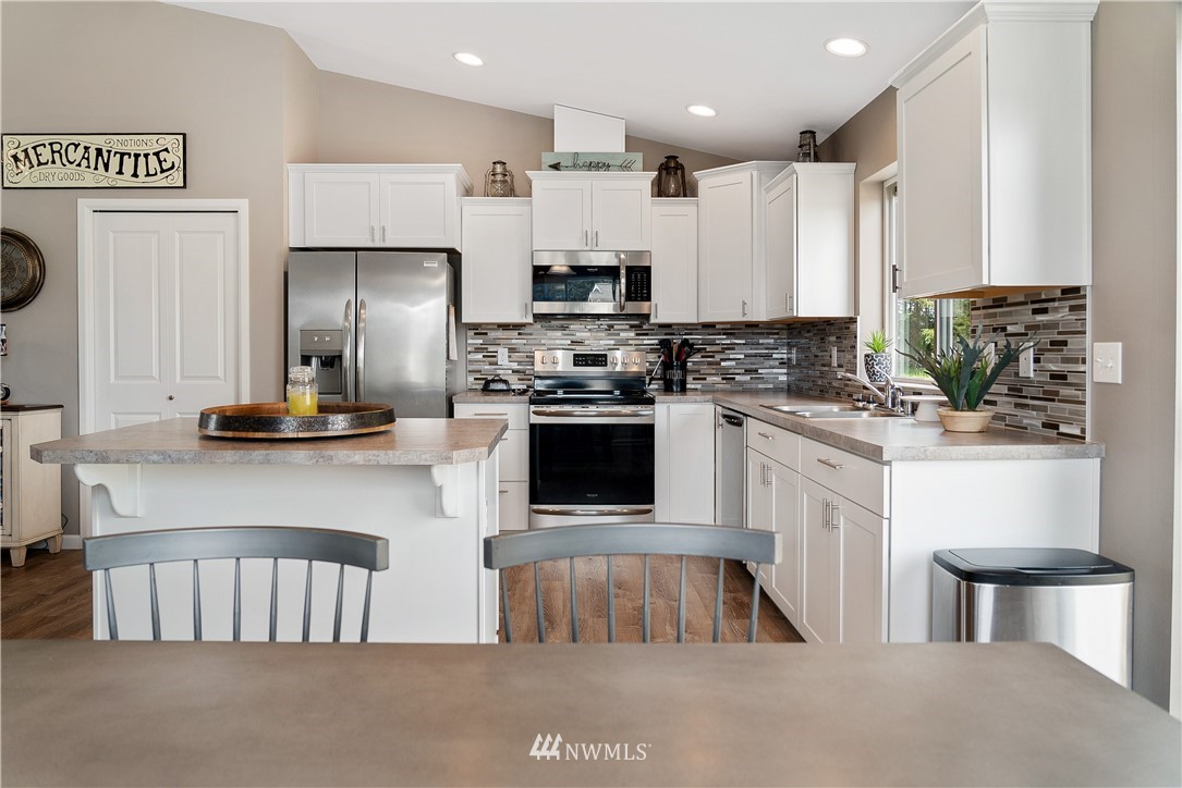 18221 Lawton Lane Southwest Rochester, WA 98579 - Photo 14 of 36 a kitchen with kitchen island granite countertop a stove a sink a refrigerator and a cabinets