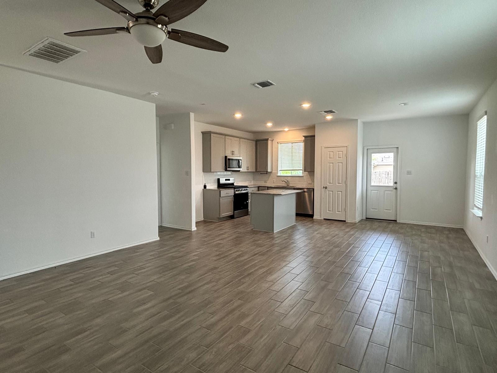 1509 Hope Rnch Road Leander, TX 78641 - Photo 7 of 25 Unfurnished living room with dark wood-style floors, ceiling fan, baseboards, and recessed lighting