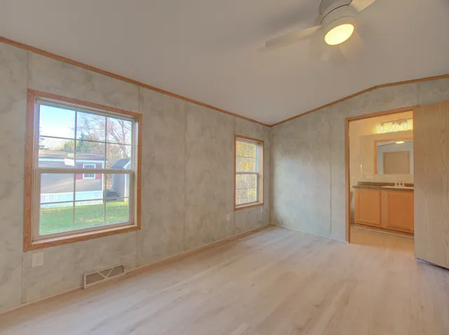 a view of empty room with window and wooden floor