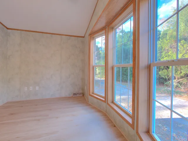a view of a big room with wooden floor and windows