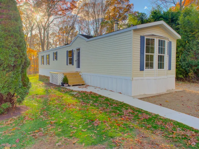 a front view of house with yard and trees in the background