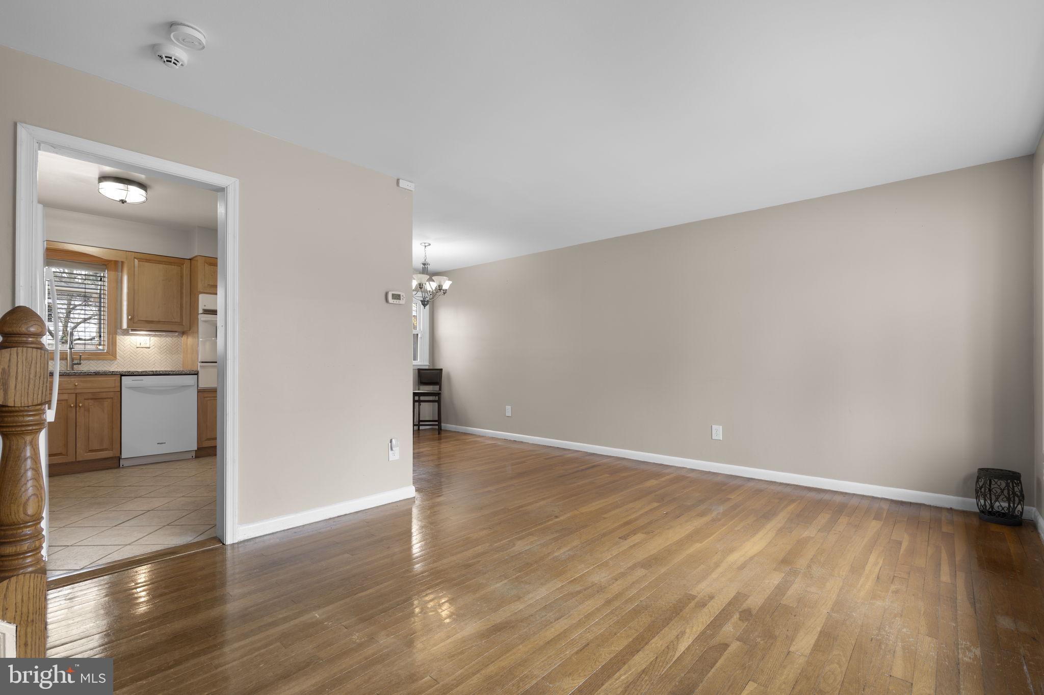 3008 Hardy Avenue Silver Spring, MD 20902 - Photo 3 of 29 an empty room with wooden floor and a kitchen