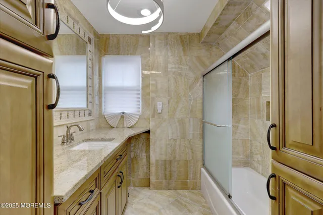 a bathroom with a granite countertop bathtub shower sink and mirror