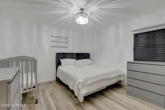 a bedroom with a bed and a chandelier