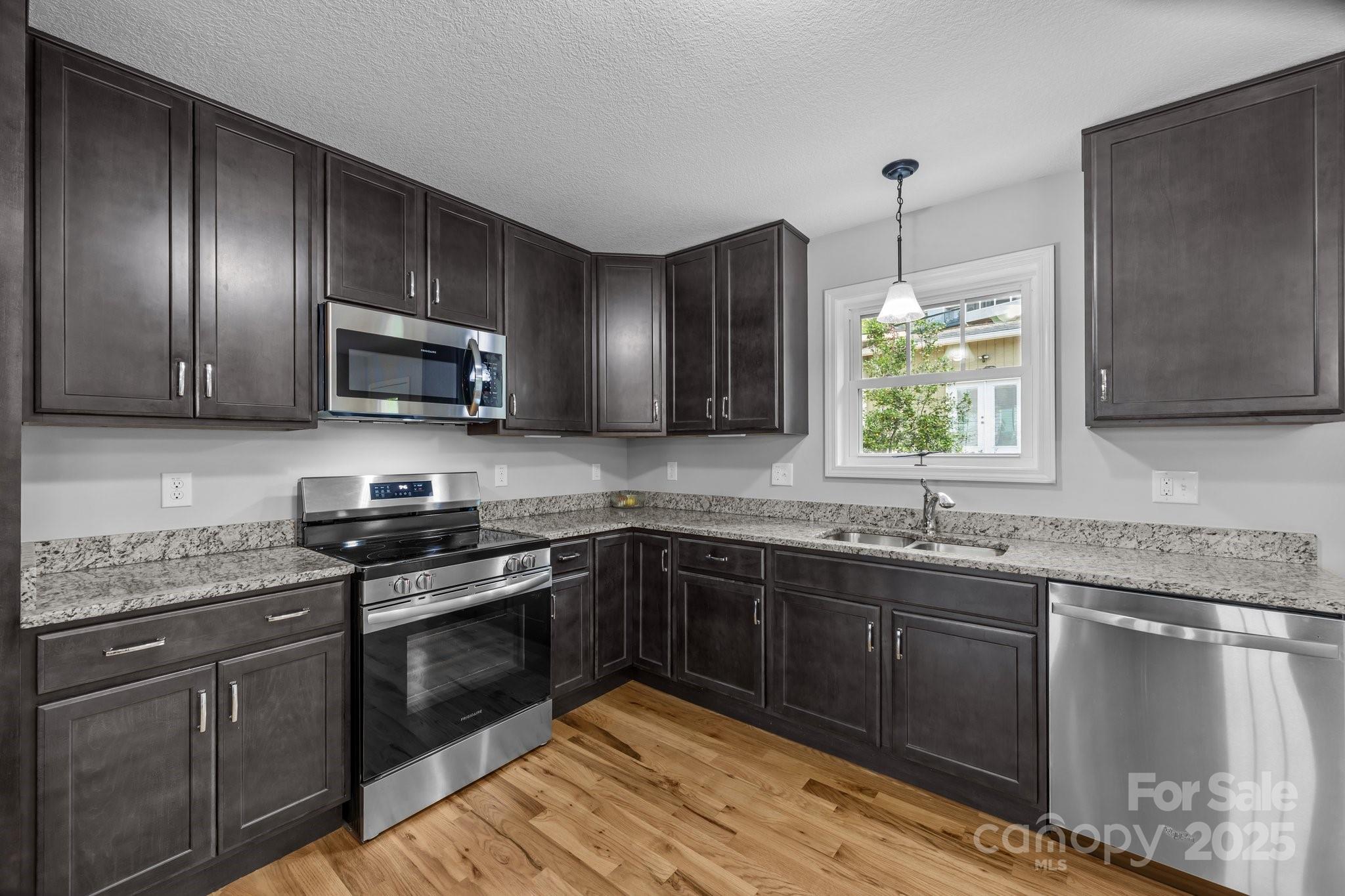 17 Laurel Road Arden, NC 28704 - Photo 11 of 45 a kitchen with stainless steel appliances granite countertop wooden cabinets a stove top oven a sink and dishwasher