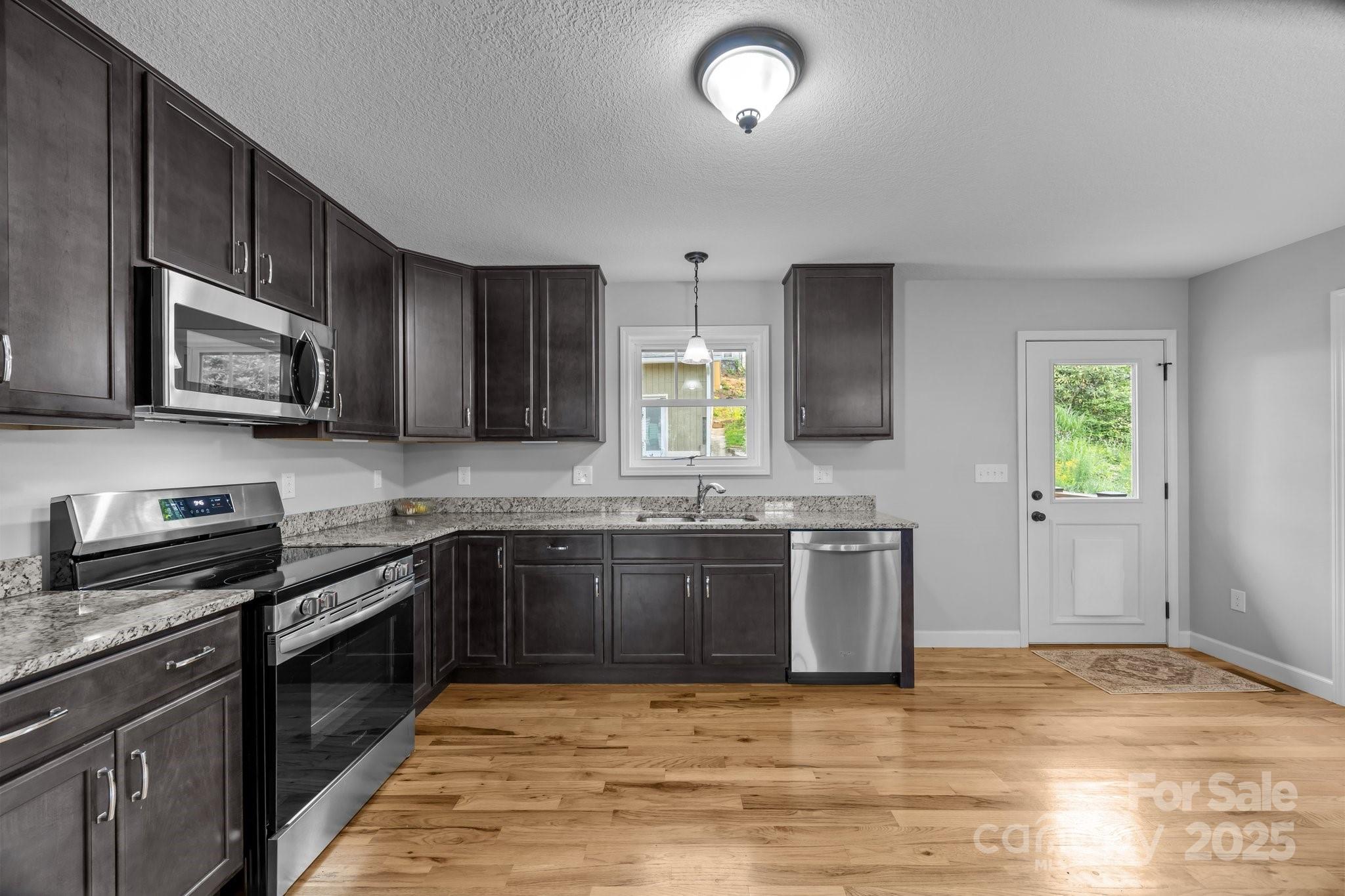 17 Laurel Road Arden, NC 28704 - Photo 10 of 45 a large kitchen with stainless steel appliances granite countertop a stove microwave and sink