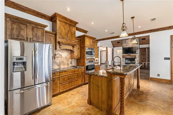 a kitchen with stainless steel appliances granite countertop a refrigerator a stove and a sink with wooden floor