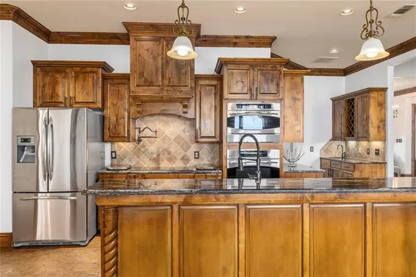 a kitchen with stainless steel appliances granite countertop a refrigerator and a stove