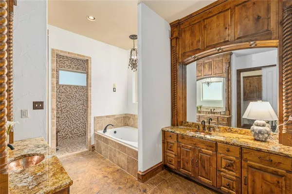 a spacious bathroom with a tub sink and mirror