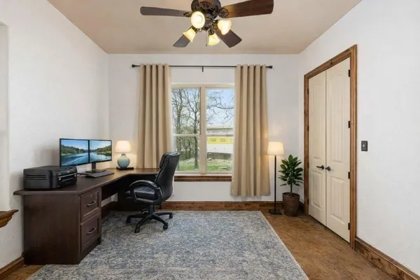 a view of a workspace with furniture and a window