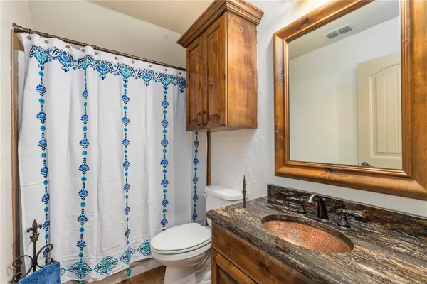a bathroom with a granite countertop sink toilet and shower