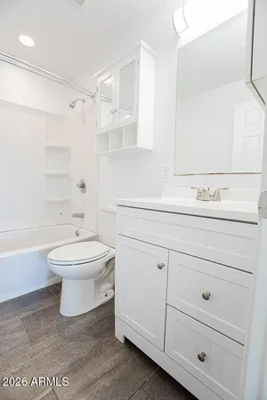 an empty room with wooden floor and a ceiling fan
