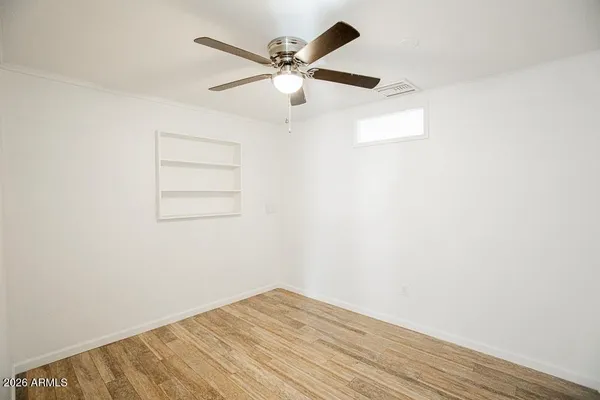 an empty room with fan and windows