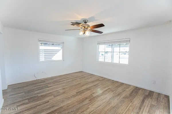 a view of a hallway with wooden floor and a bathroom