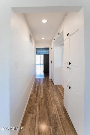 a kitchen with stainless steel appliances a refrigerator a sink dishwasher a stove and white cabinets with wooden floor
