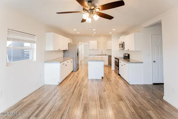a kitchen with granite countertop a sink stove and refrigerator