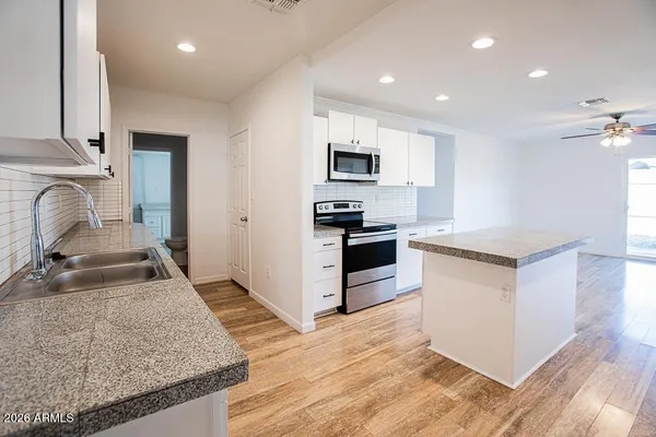 a large kitchen with a stove and a sink