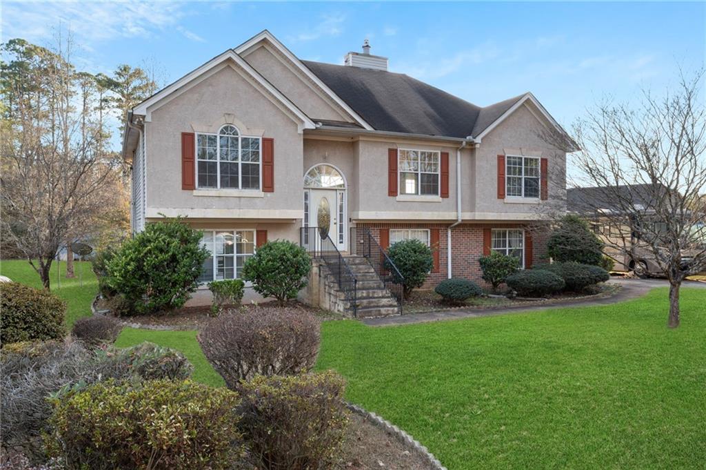 a front view of a house with a garden and plants