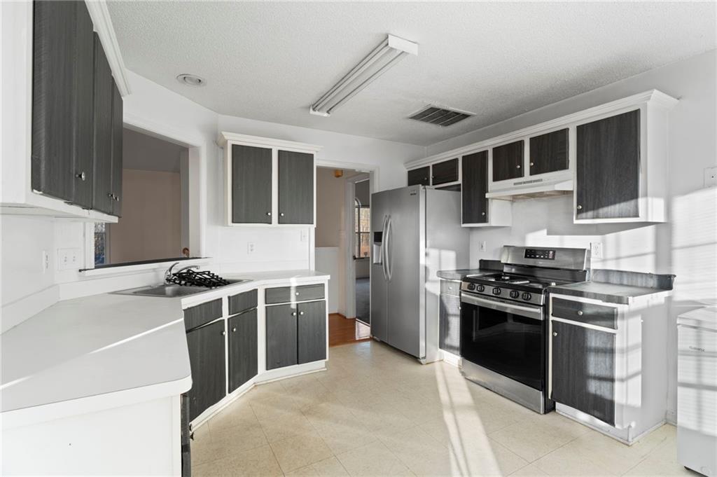 6644 Virlyn B Smith Road Fairburn, GA 30213 - Photo 18 of 43 a kitchen with stainless steel appliances granite countertop a stove and a sink