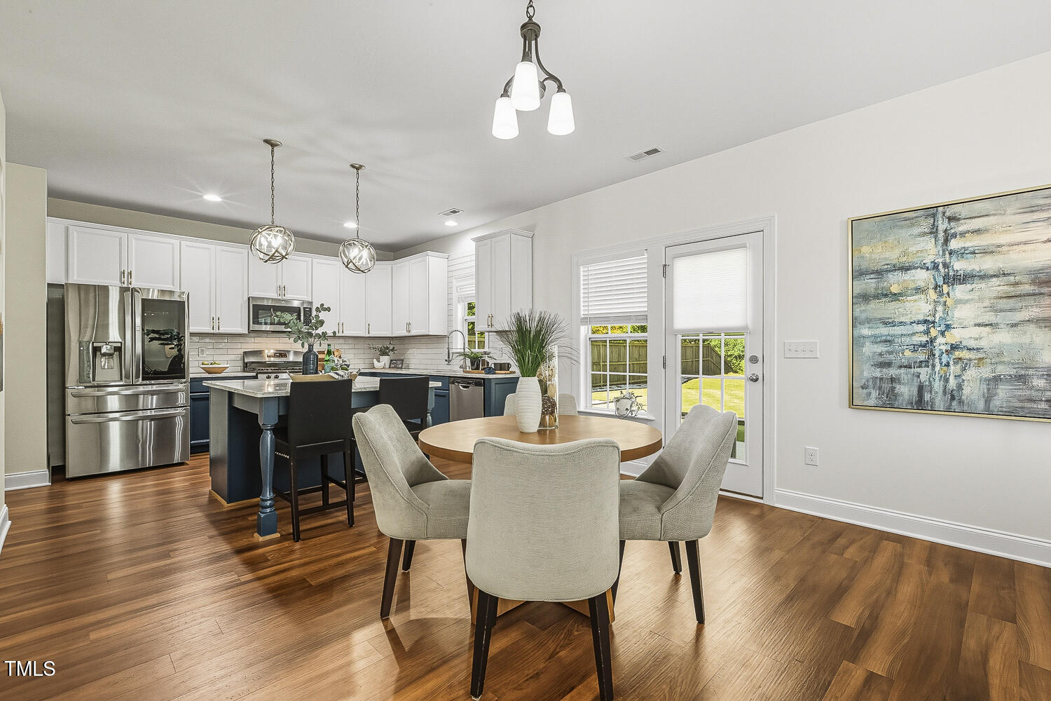 5180 Copain Cove Fuquay-Varina, NC 27526 - Photo 10 of 45 a dining room with kitchen island stainless steel appliances wooden floor and a chandelier