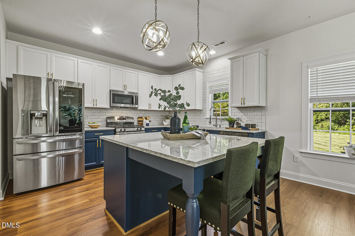 5180 Copain Cove Fuquay-Varina, NC 27526 - Photo 12 of 45 a kitchen with stainless steel appliances granite countertop a sink a stove a refrigerator cabinets and a dining table