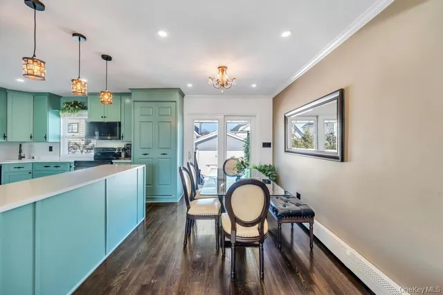 a very nice looking dining room with furniture a kitchen a chandelier and wooden floor