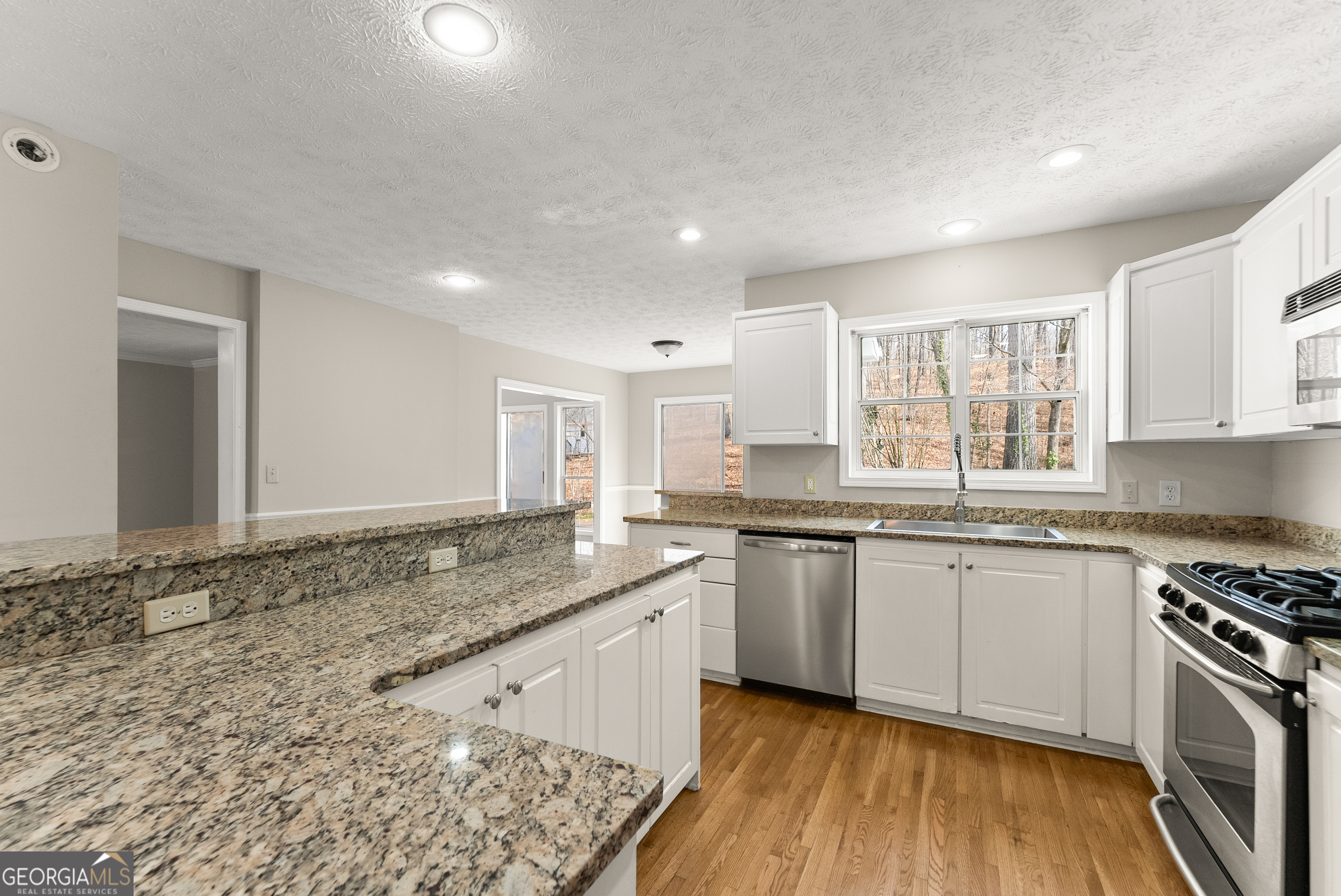 5011 Weaver Road Gainesville, GA 30507 - Photo 38 of 62 a kitchen with granite countertop sink stove and cabinets