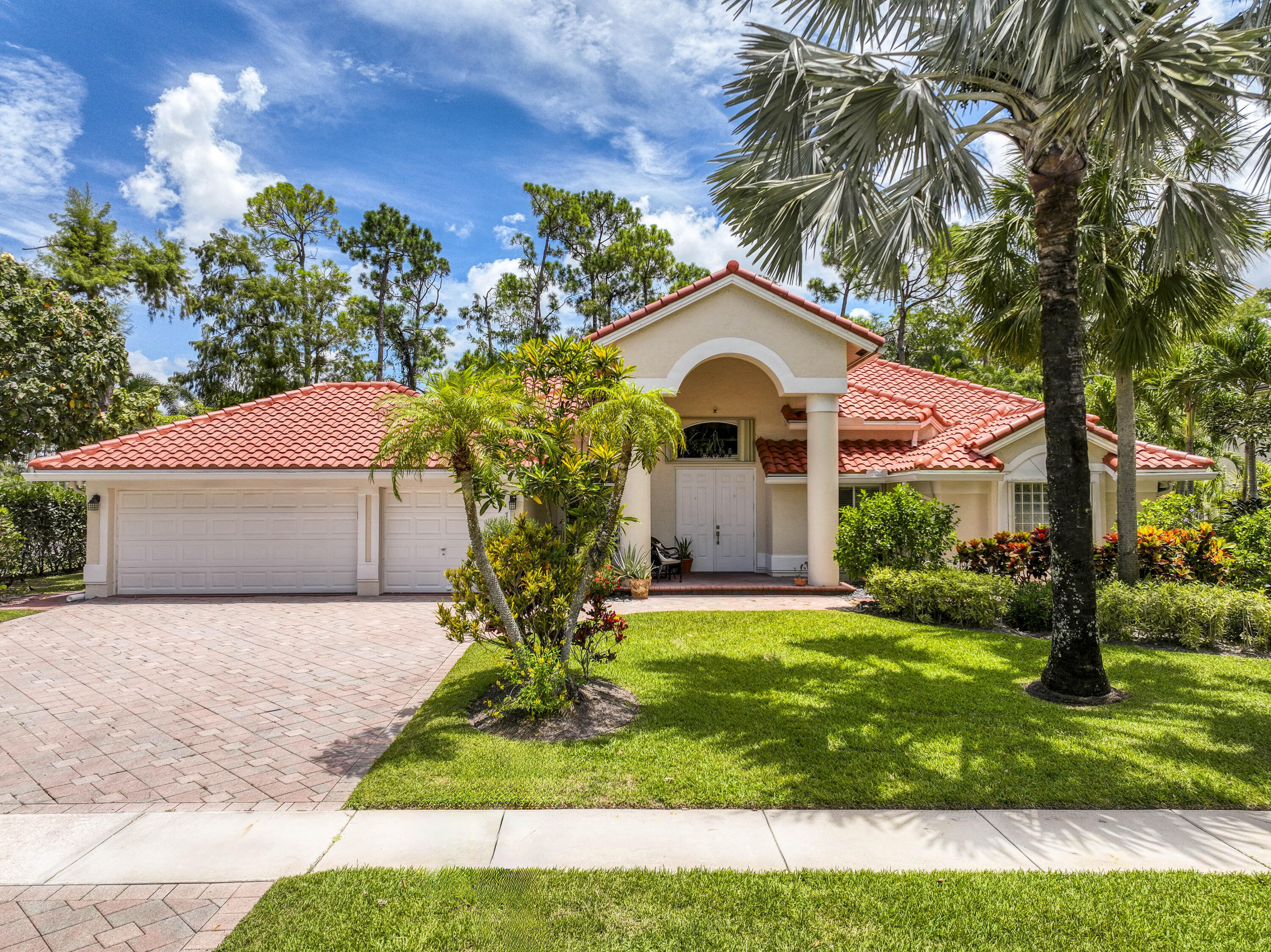 750 Cedar Cove Road Wellington, FL 33414 - Photo 2 of 37 a front view of a house with a yard and garage