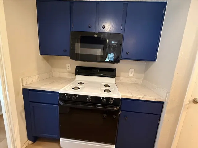 a utility room with stainless steel appliances wooden cabinets and a stove top oven