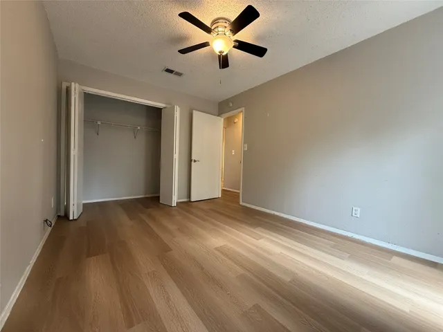 a view of an empty room and window and a ceiling fan