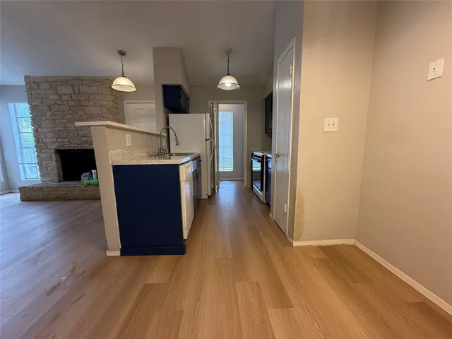 a kitchen with a wooden floor and a fireplace
