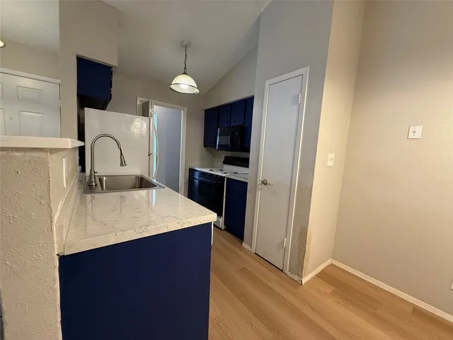 a kitchen with kitchen island a sink appliances and cabinets