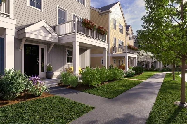 a view of a white house next to a yard and plants
