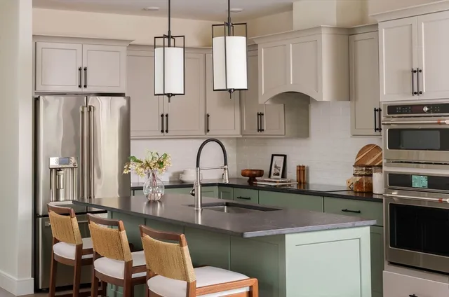 a kitchen with stainless steel appliances granite countertop a sink refrigerator and cabinets