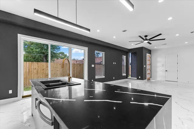a kitchen with stainless steel appliances granite countertop a sink a microwave and wooden cabinets