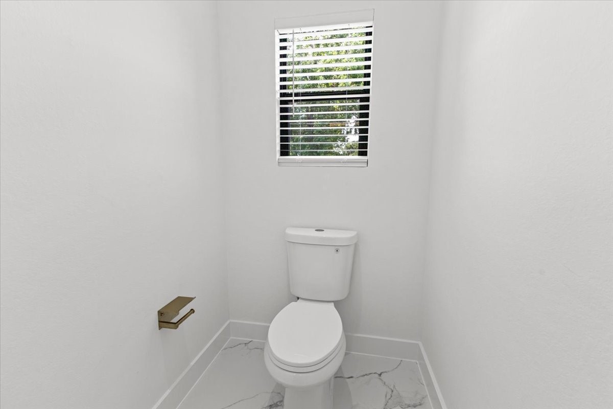 5110 Longmeadow Street, Unit B Houston, TX 77033 - Photo 16 of 25 a white toilet sitting next to a window