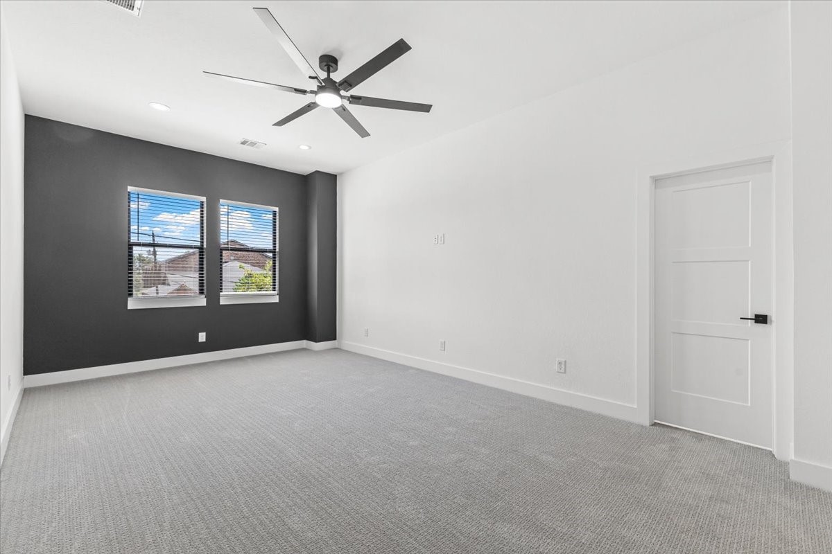 5110 Longmeadow Street, Unit B Houston, TX 77033 - Photo 20 of 25 an empty room with windows and ceiling fan