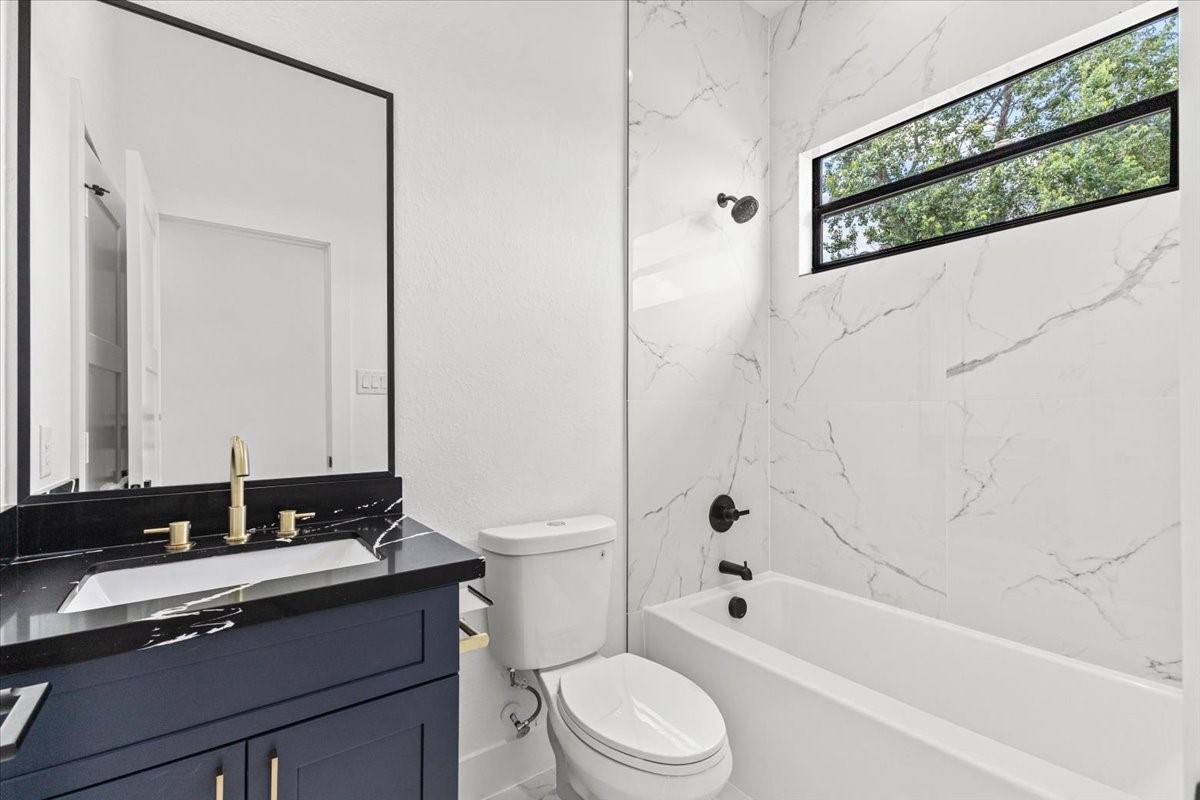 5110 Longmeadow Street, Unit B Houston, TX 77033 - Photo 23 of 25 a bathroom with a granite countertop sink a toilet and bathtub