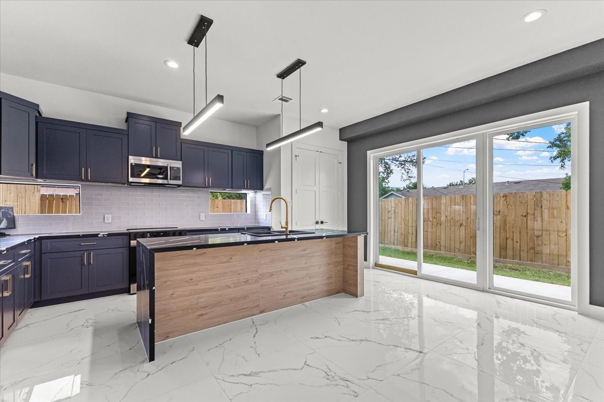 5110 Longmeadow Street, Unit B Houston, TX 77033 - Photo 6 of 25 a kitchen with stainless steel appliances granite countertop a stove top oven a sink a counter space and cabinets