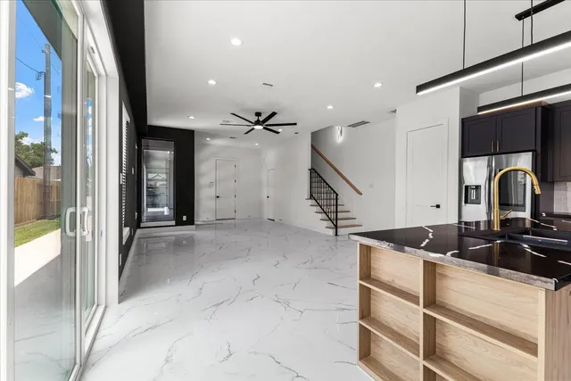 a kitchen with granite countertop a sink stainless steel appliances and cabinets
